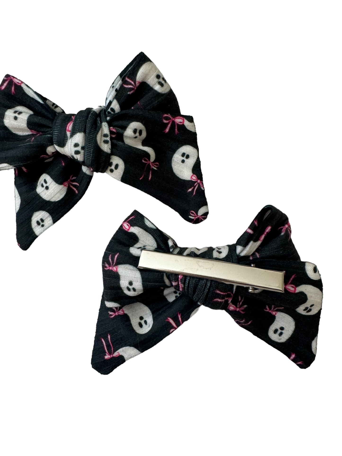 Packaged hair bows with black ghost patterns and pink bows, displayed on a white background.