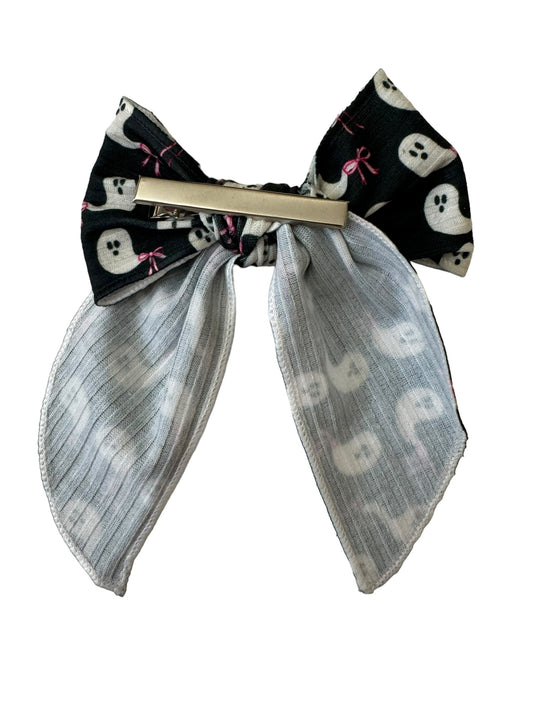 Packaged hair bows with black ghost patterns and pink bows, displayed on a white background.