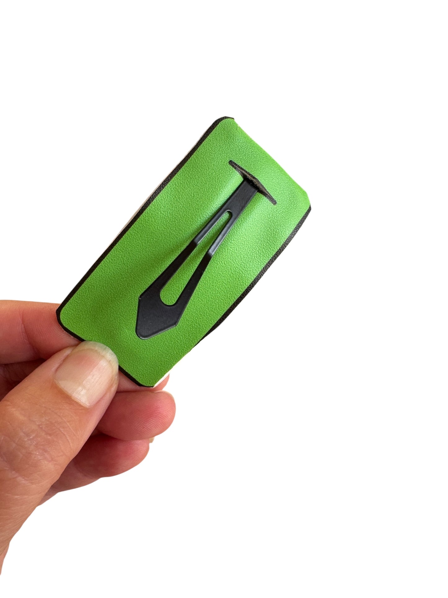 Green hair clip with black clip held by a hand on a white background