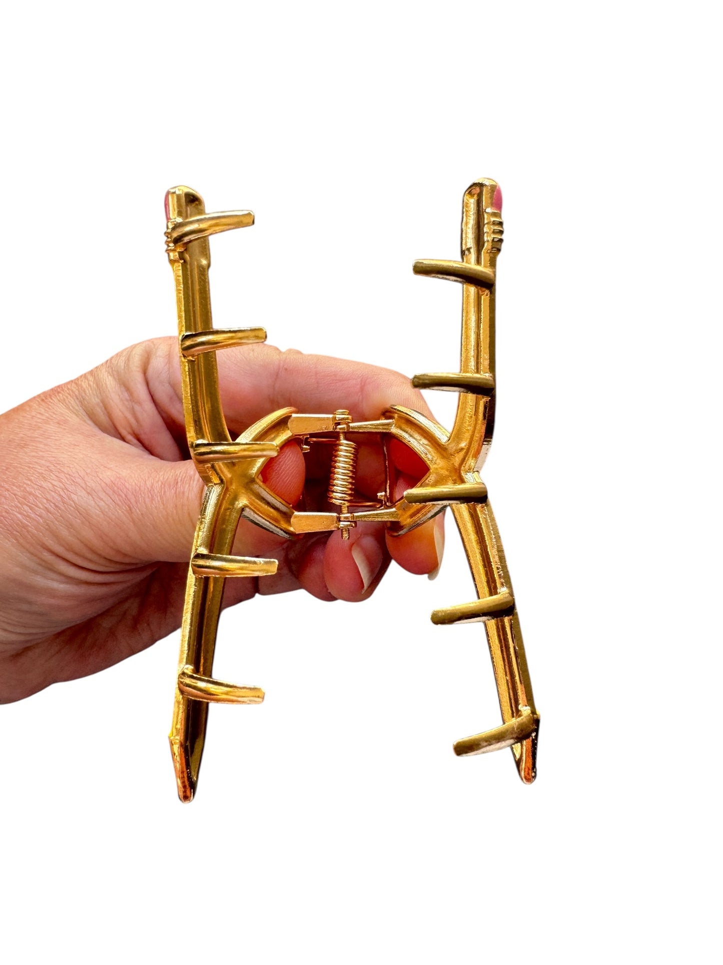 Yellow pencil claw clip with a unique design held by a hand on a white background