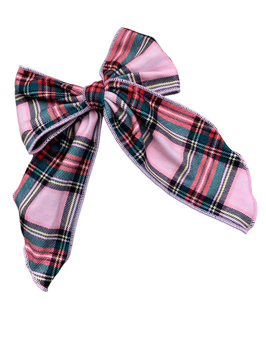 A flannel plaid hair bow with red, blue, and green checkered pattern on an isolated background.