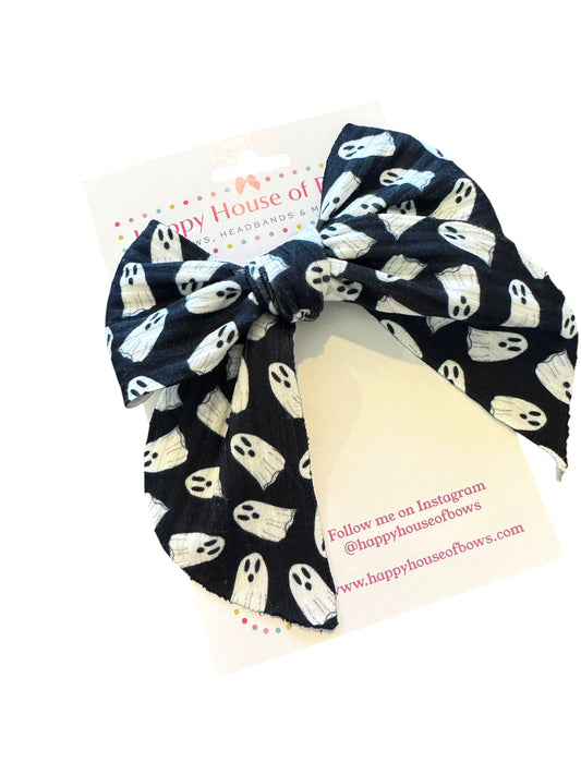 Black hair bow with ghost pattern on a white card, branded 'Happy House of Bows'.