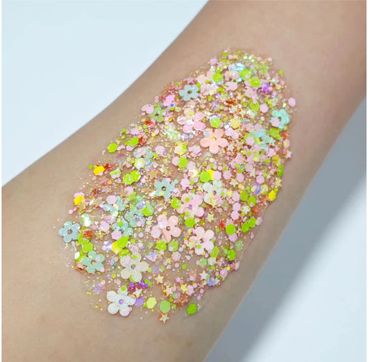 Floral Pastel hair and body glitter gel  on a person's arm against a light blue background