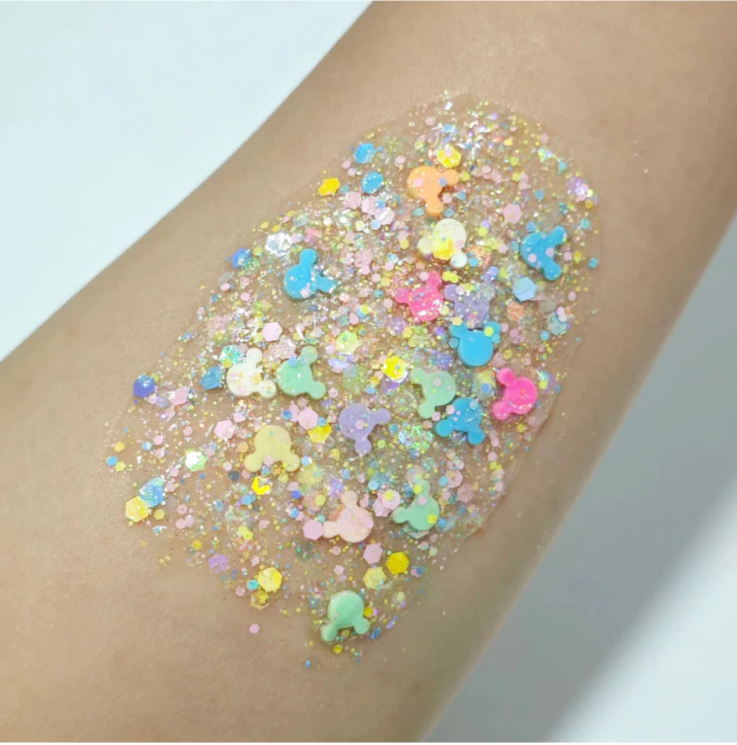 Colorful glitter hair gel on a person's arm with a light background