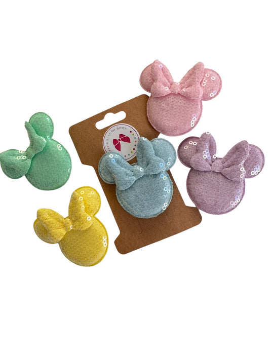 Set of colorful sequin hair clips on a brown card with a white background