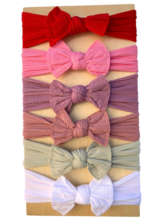 Set of colorful baby headbands displayed on a wooden board
