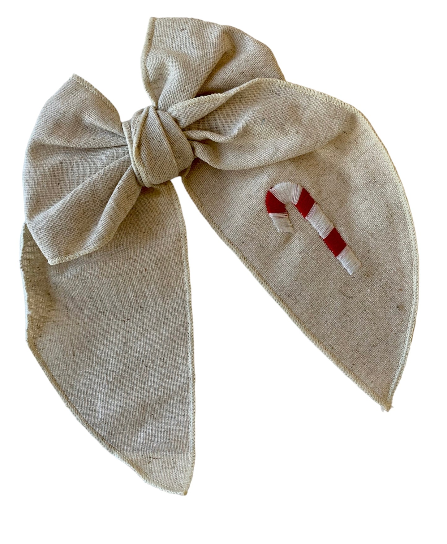 A beige linen hair bow with a Christmas candy cane embroidery on it, attached to an alligator clip.