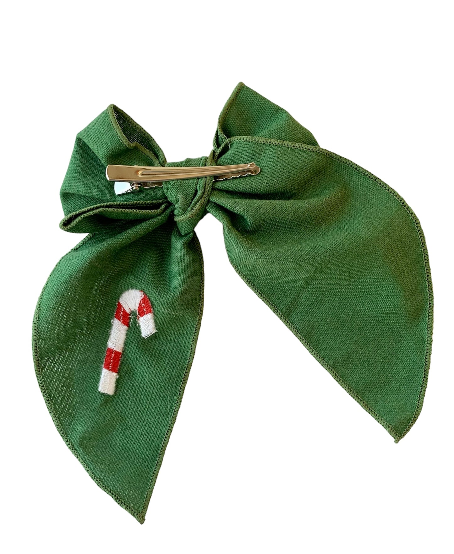 A green linen hair bow with a Christmas candy cane embroidery on it, attached to an alligator clip.