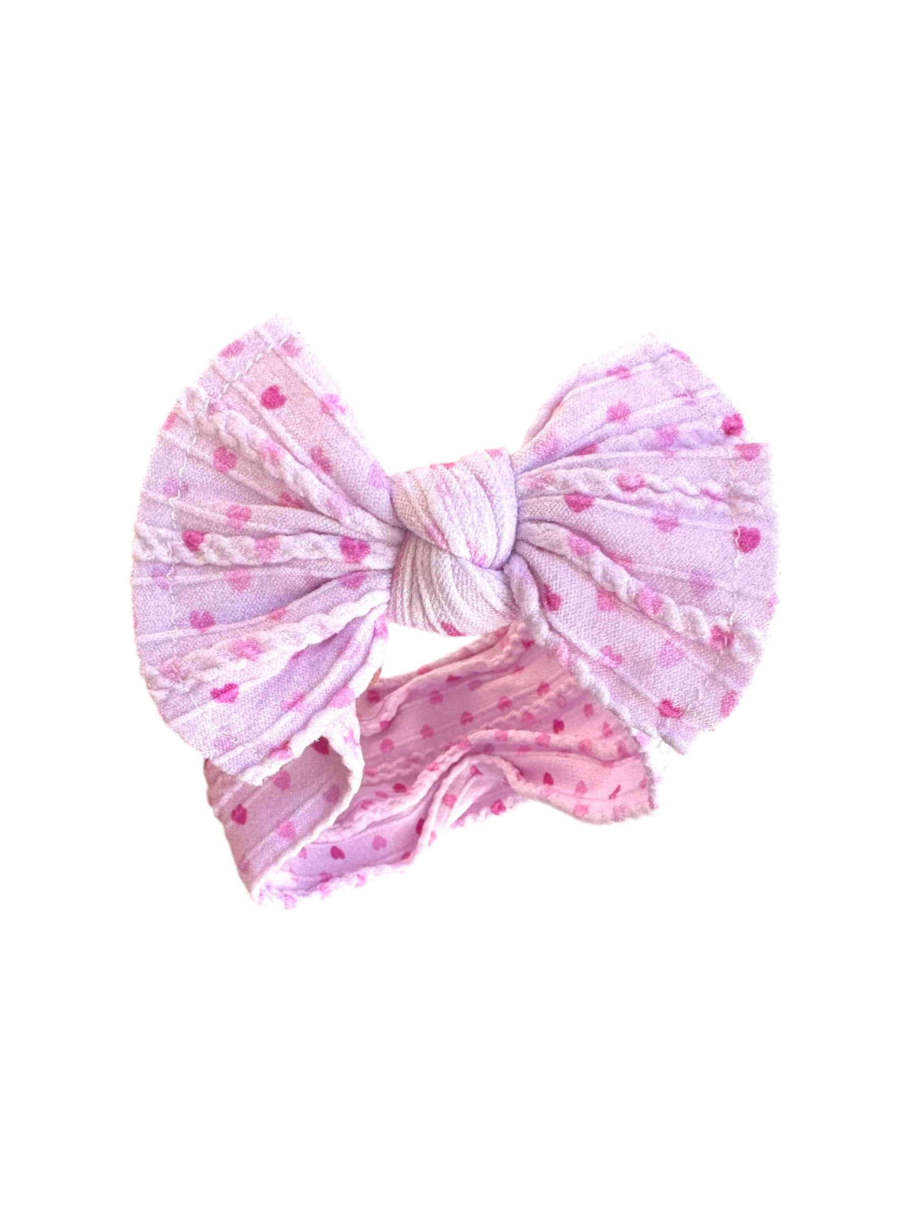 A pink heart  patterned infant headband for babies with large bow