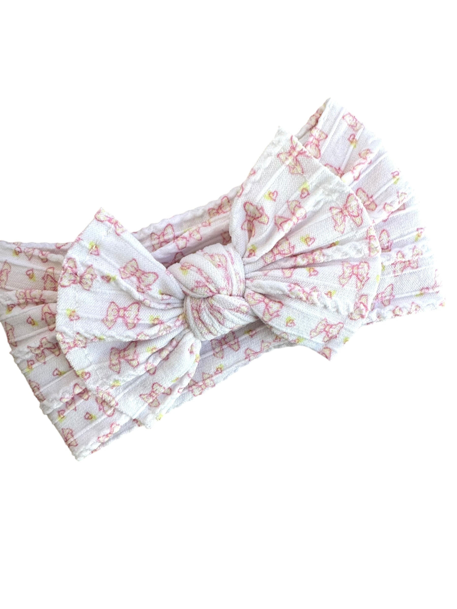 A pink bow patterned infant headband for babies with large bow