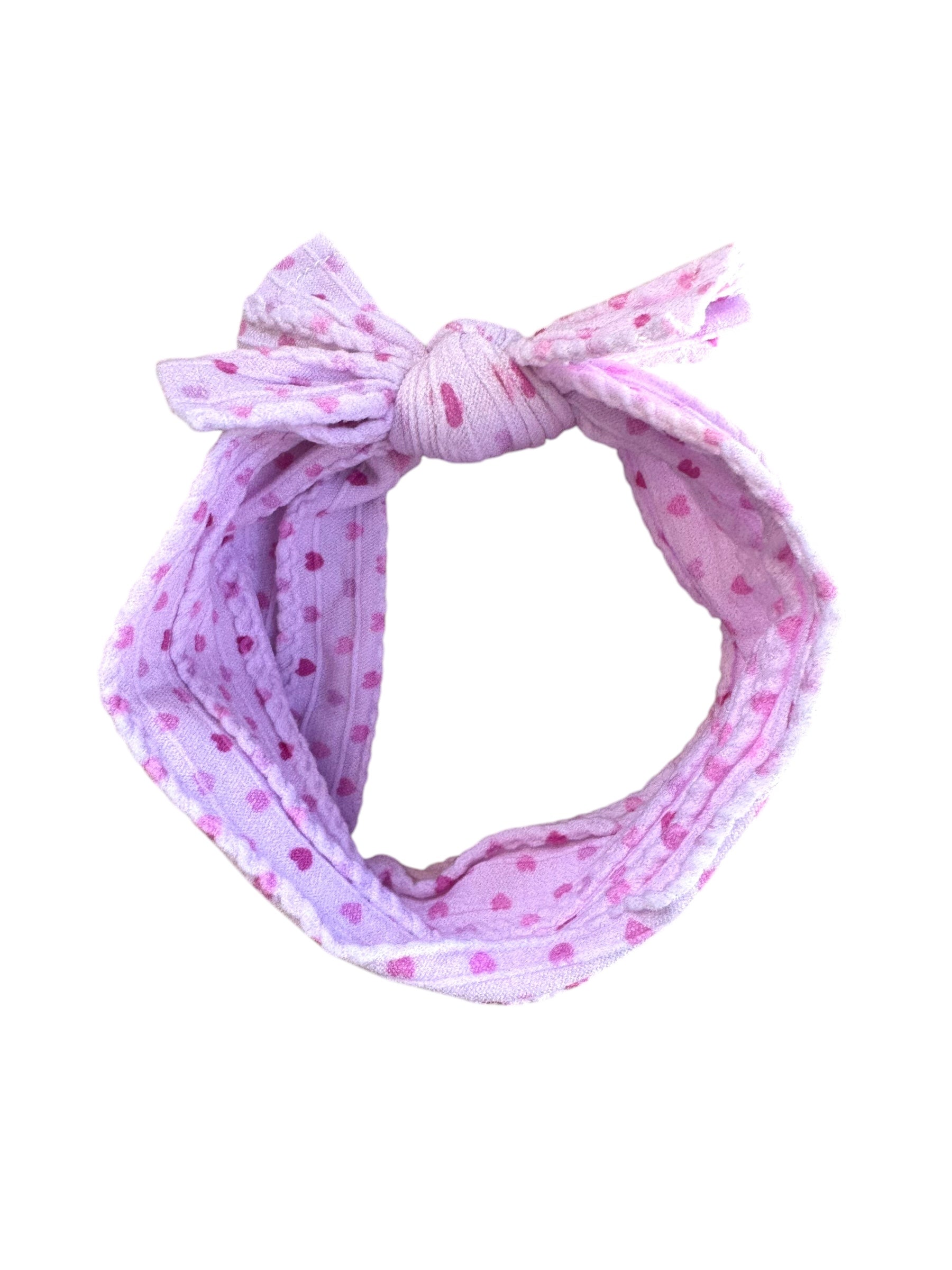 A pink heart  patterned infant headband for babies with large bow