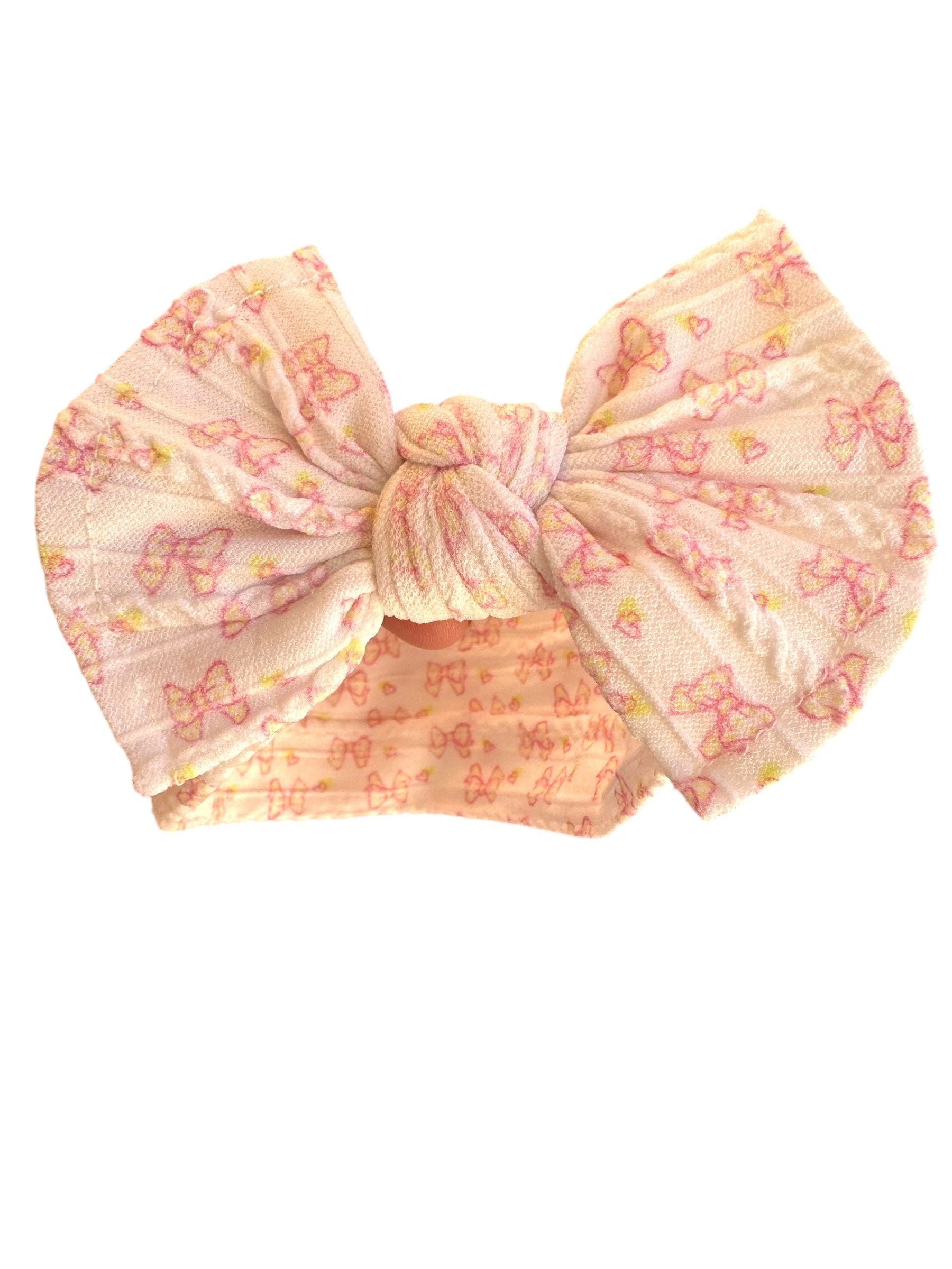 A pink bow patterned nylon headband for babies with large bow