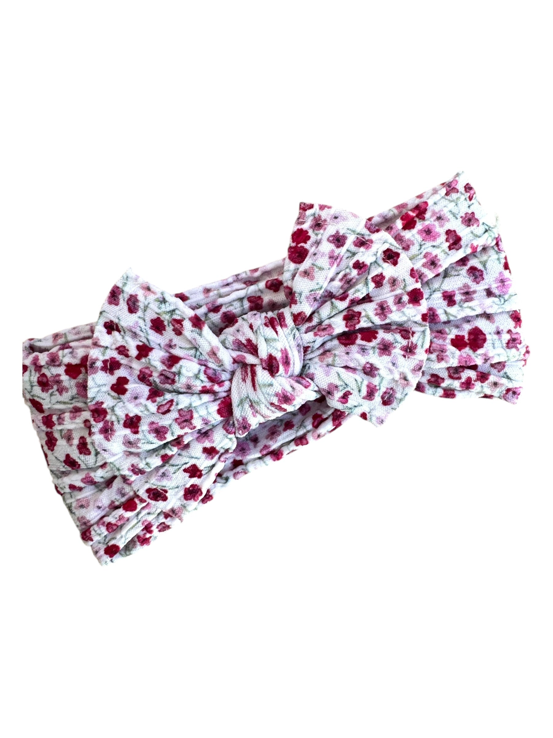 A pink and red floral patterned nylon headband for babies with large bow