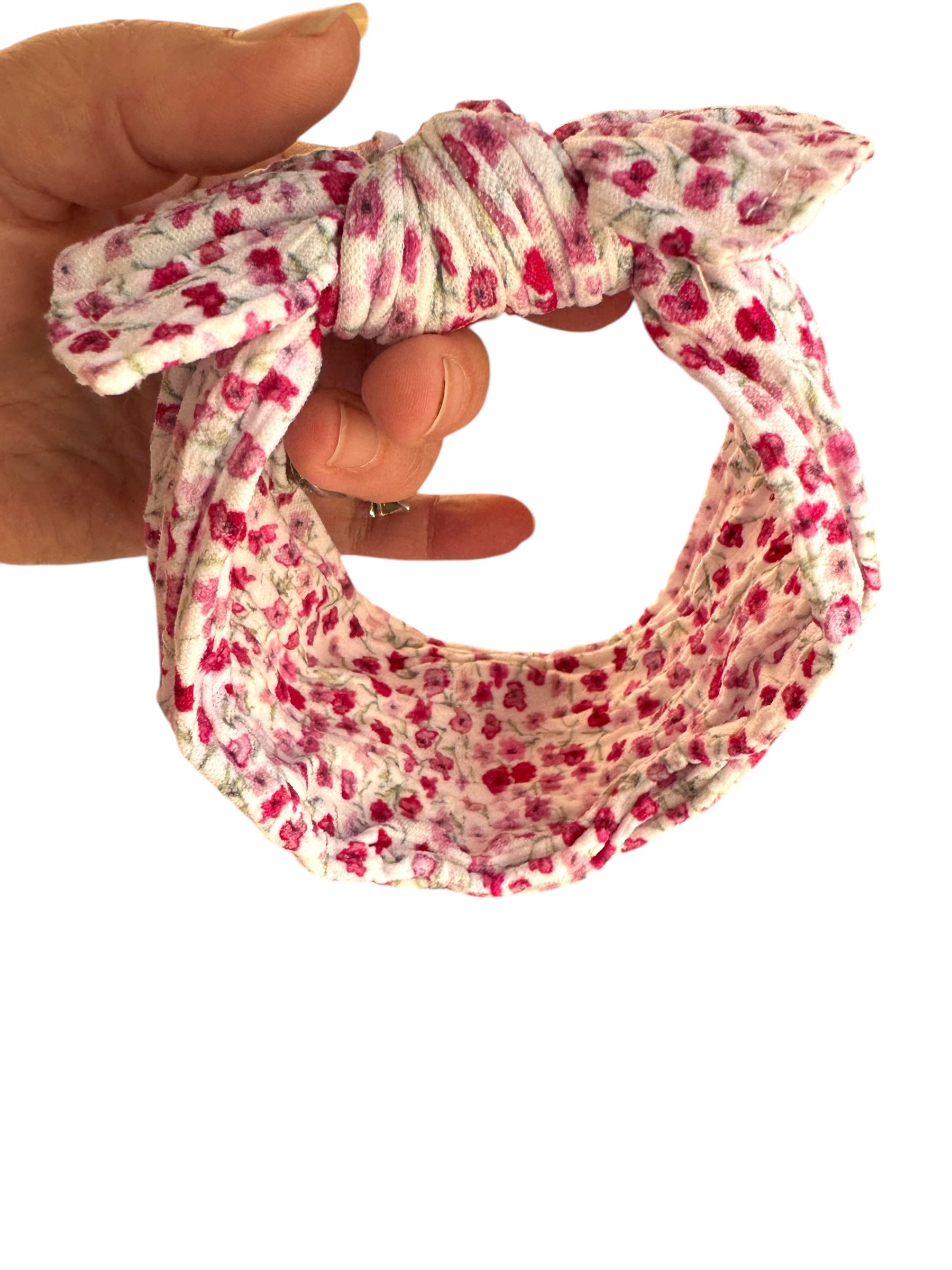 A pink and red floral patterned nylon headband for babies with large bow