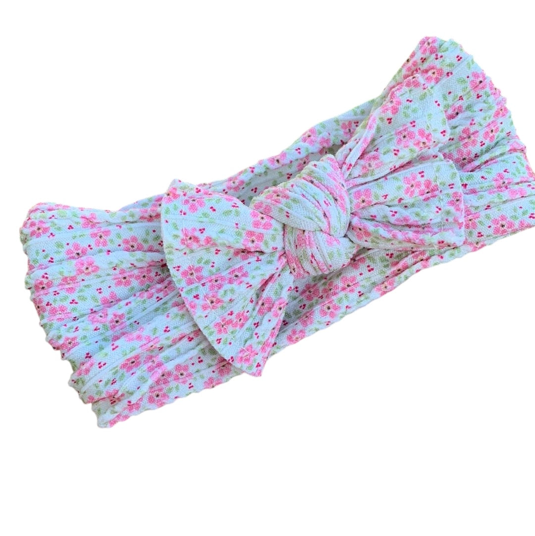 A pink and aqua flower patterned nylon headwraps for babies with large bow