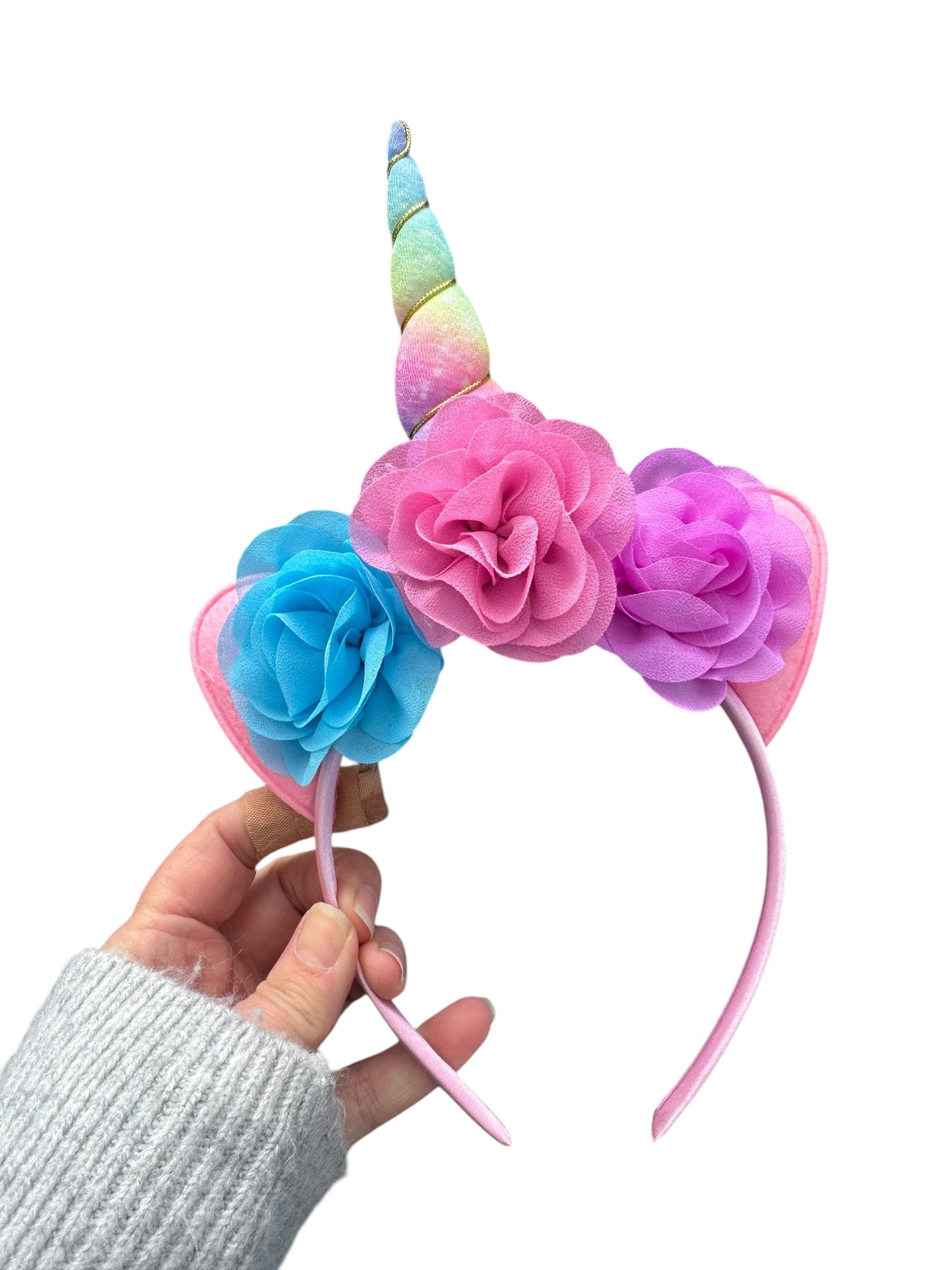 blue, pink and purple unicorn headbands with pastel rainbow unicorn horn in a hand