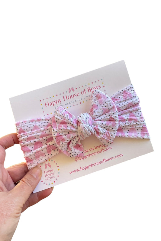Pink and white polka dot headband held over a card with 'Happy House of Bows' branding.