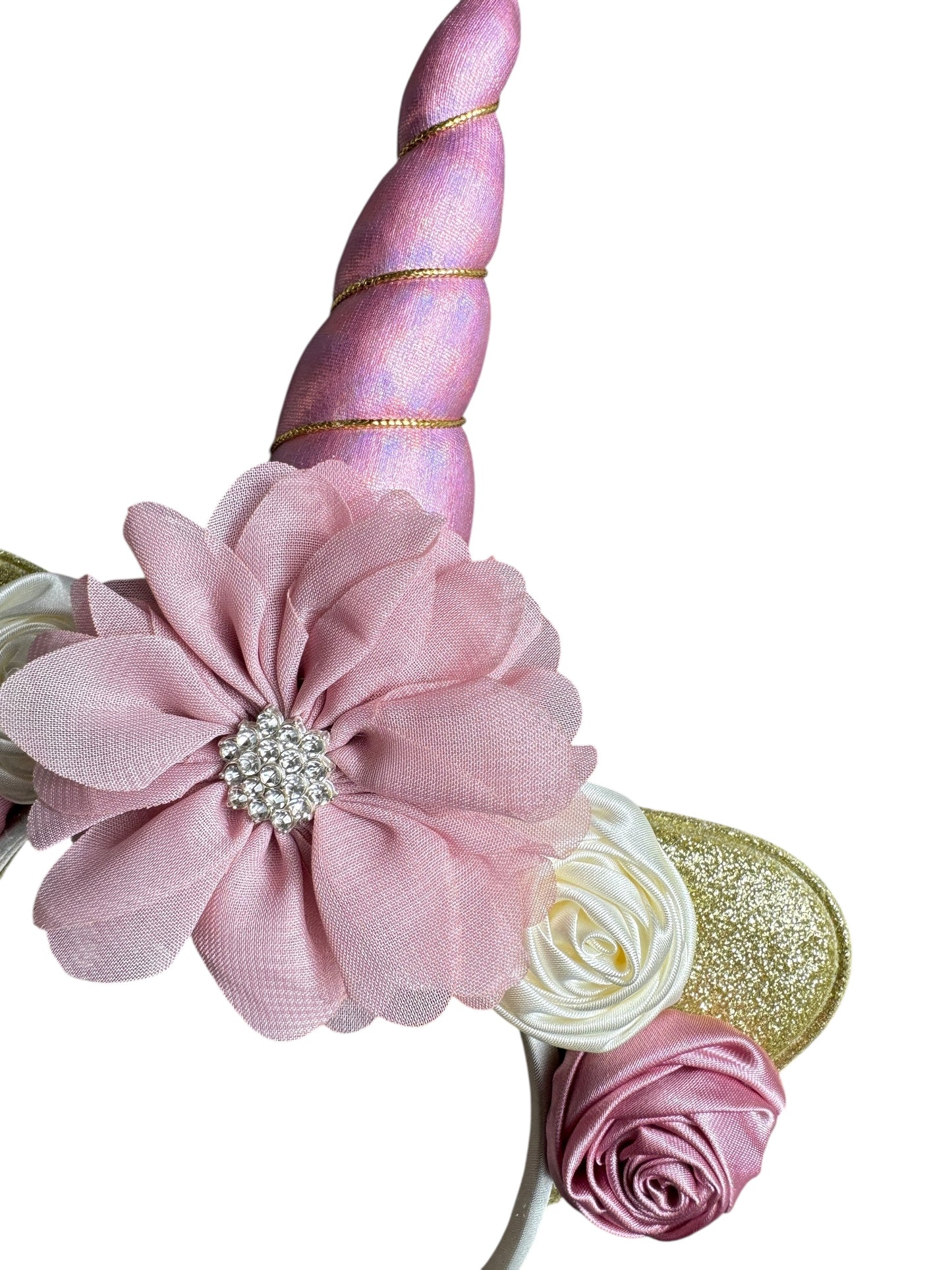 Decorative hair bow with pink flower, unicorn horn, and gold accents on a white background
