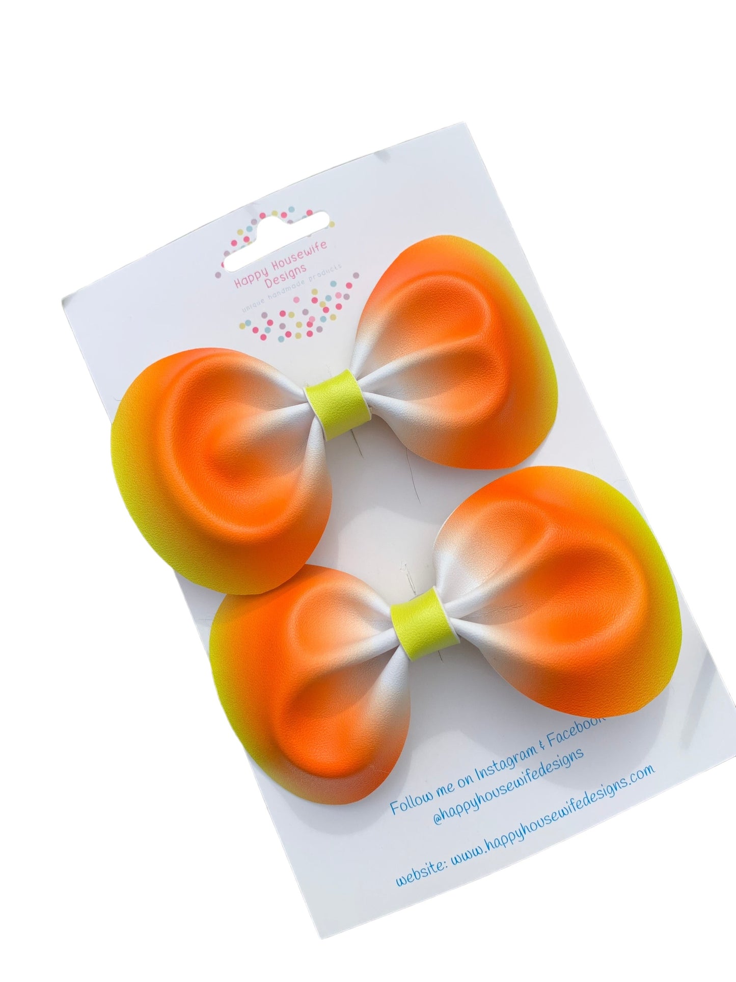 A set of faux leather hair bows in various colors with an alligator clip attached, displayed on a card.