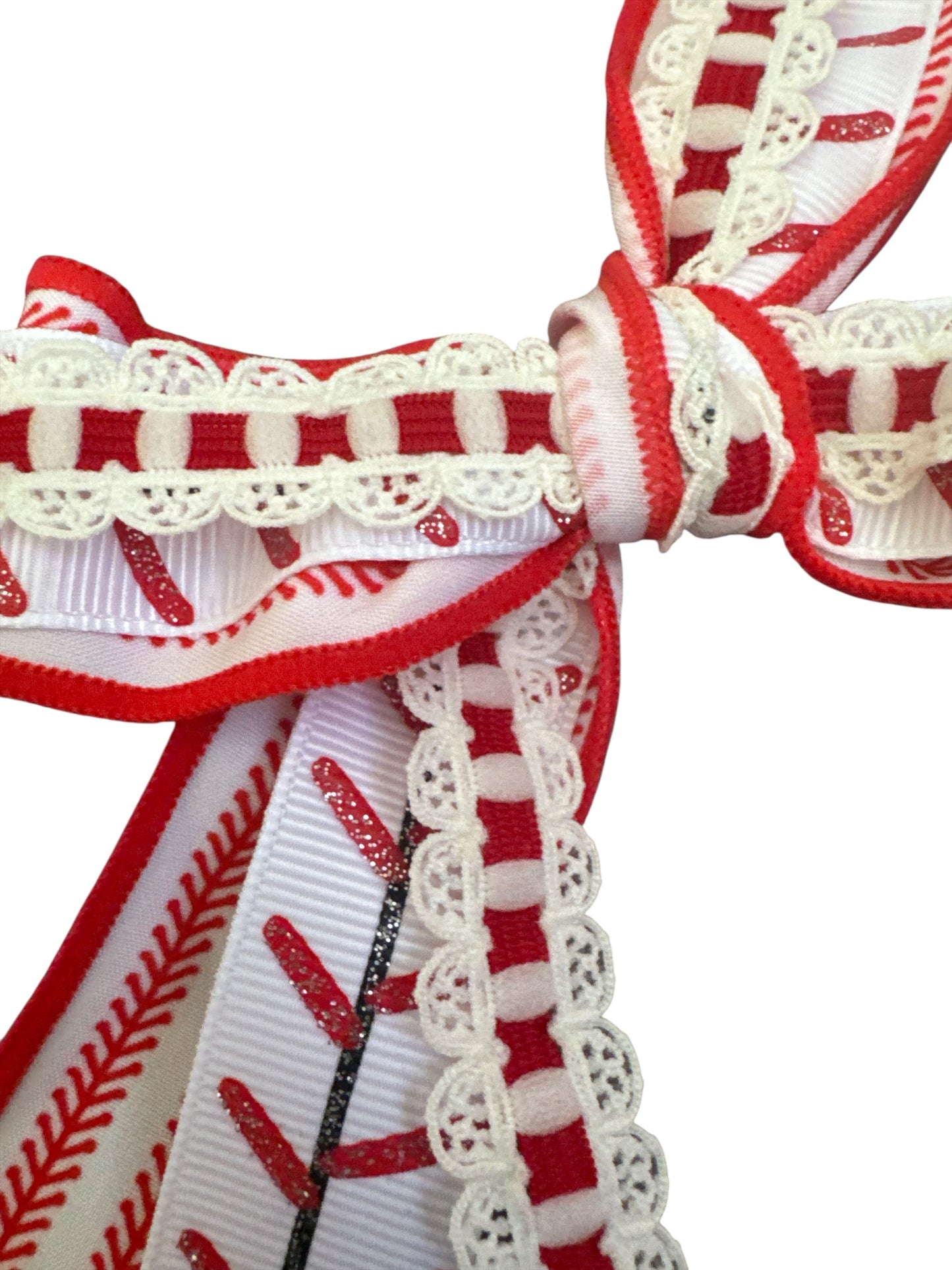 Close-up of red and white baseball hair bow with lace details on a white background