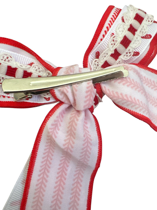 Decorative baseball ribbon hair bow with red and white patterns on a white background