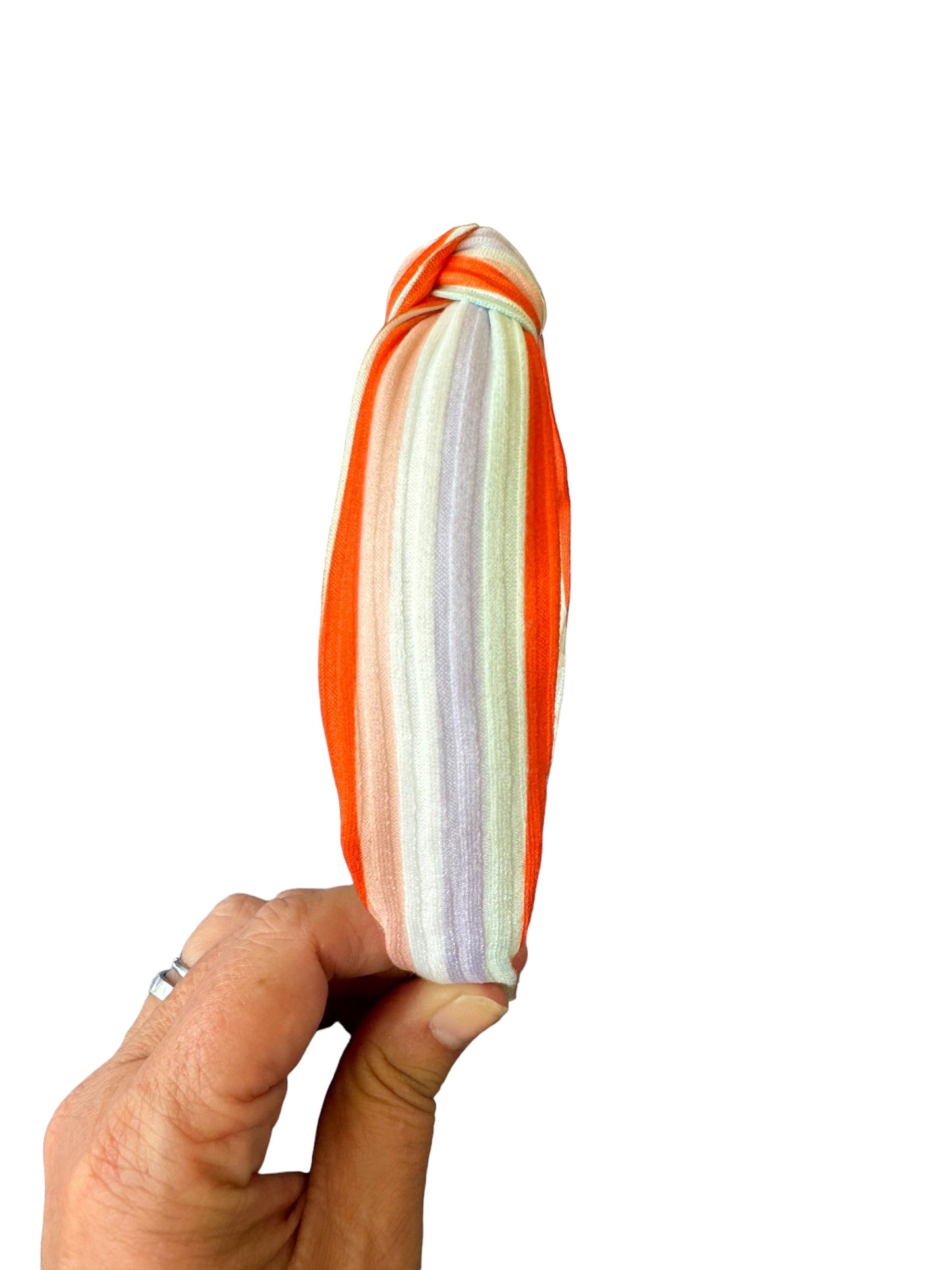 hand holding fall stripe headband on white background