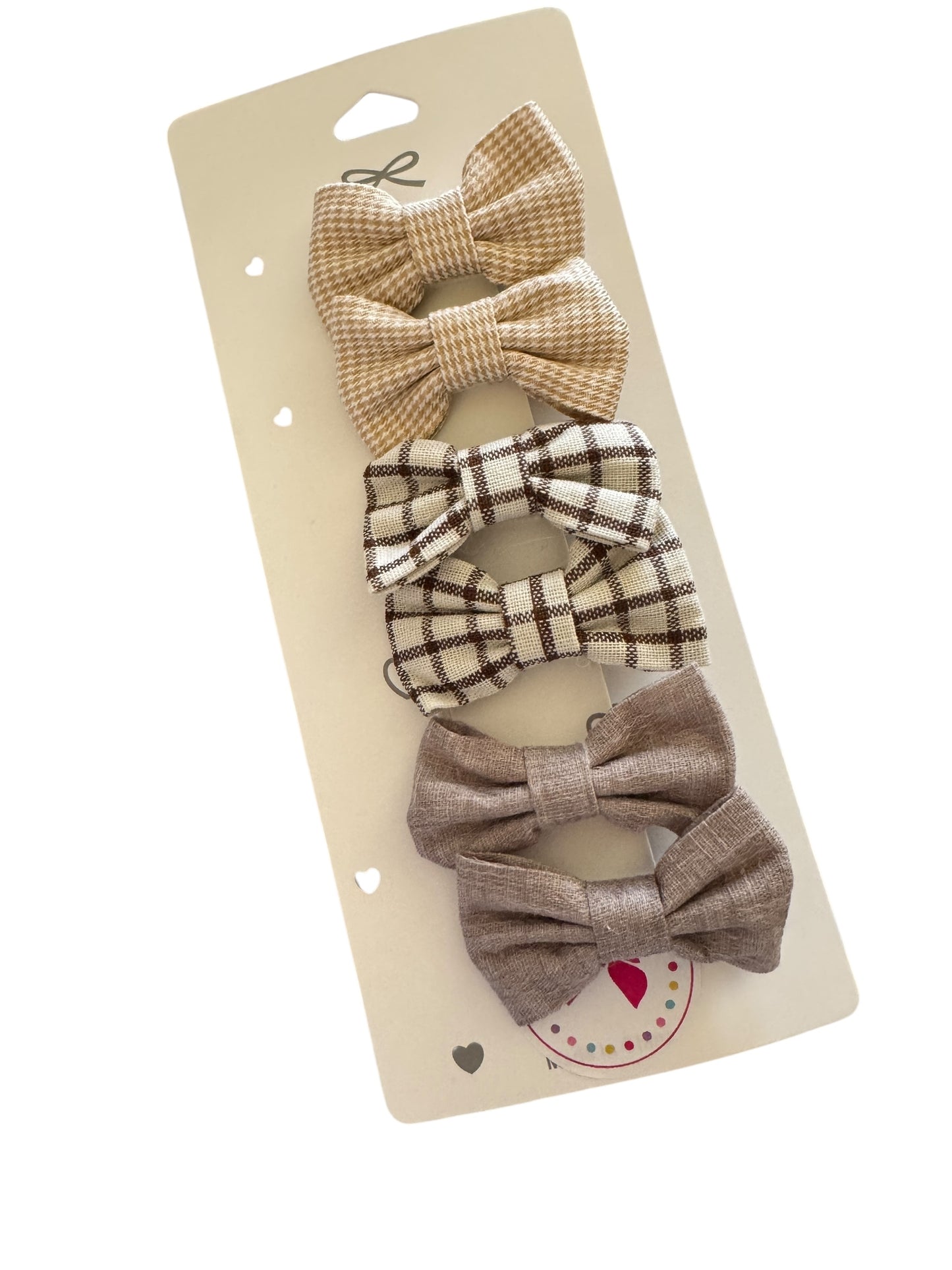 Set of plaid hair bows on a beige card with a heart design.