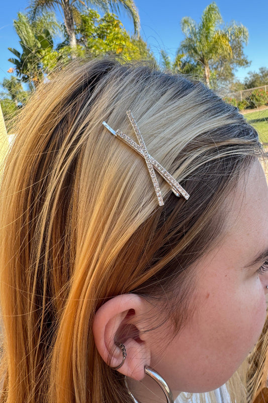 Close-up of a person's hair with a decorative hair clip outdoors.
