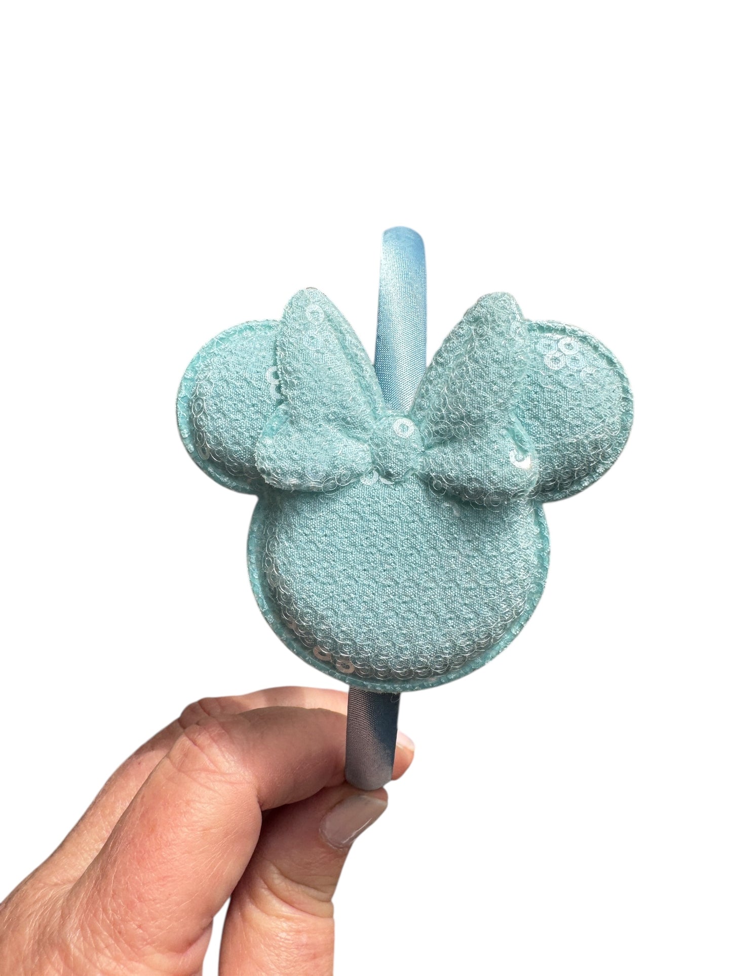 Light blue bath pouf with a handle held by a hand on a white background