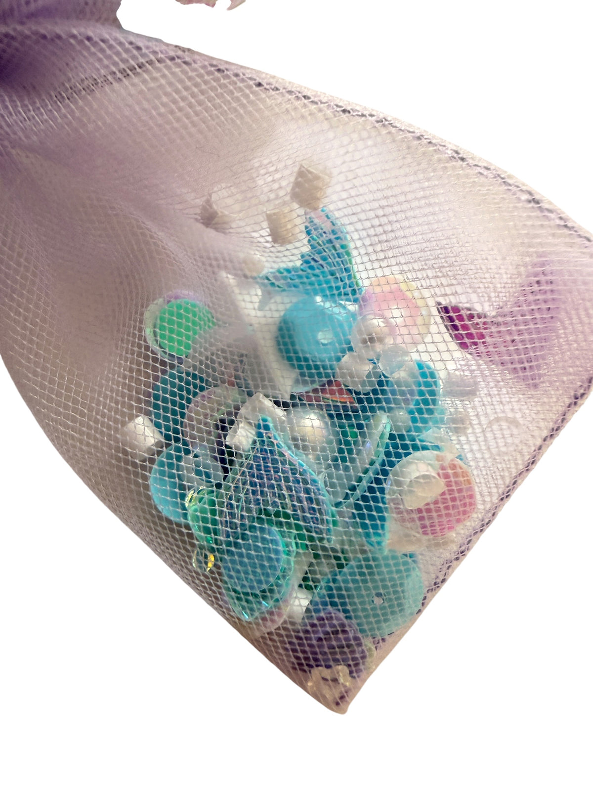 A translucent lavender mesh bow filled with assorted colorful plastic caps or lids, photographed against a plain white background.