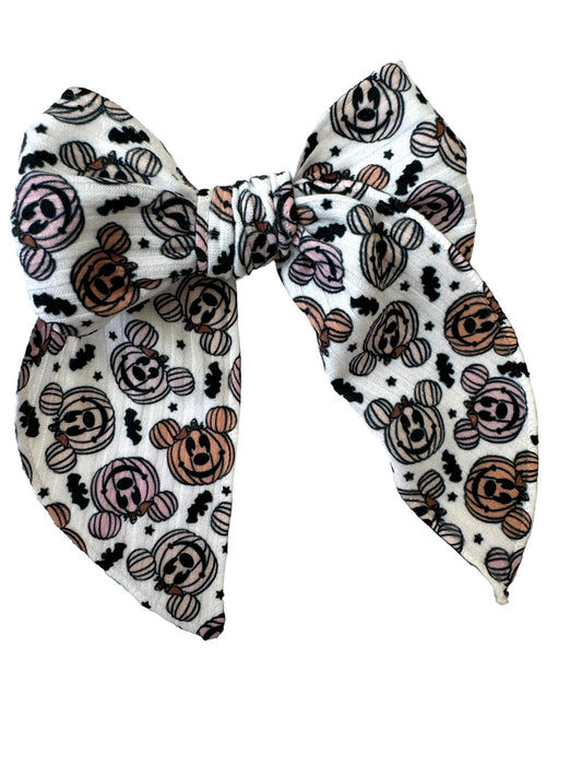 A set of hair bows with a pumpkin and mouse pattern displayed on alligator clips