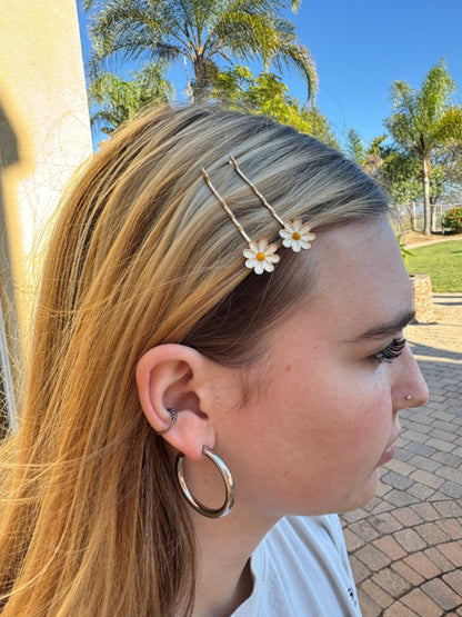 Woman with floral hairpins and hoop earrings outdoors