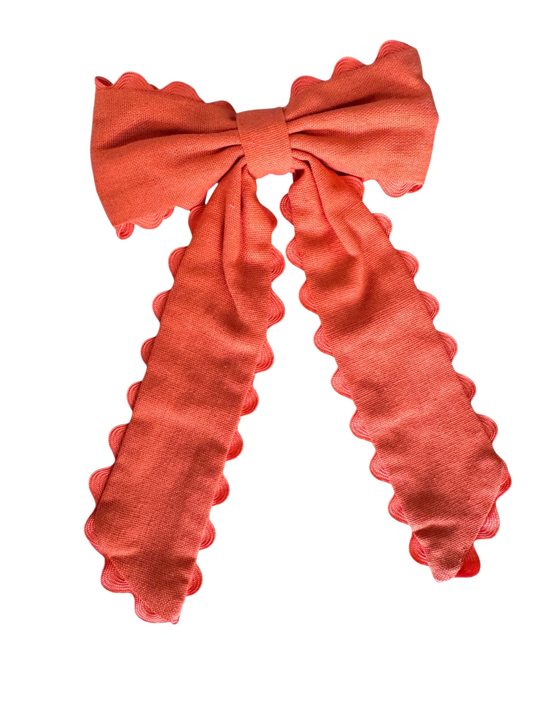 orange-colored bow with ruffled edges on a white background