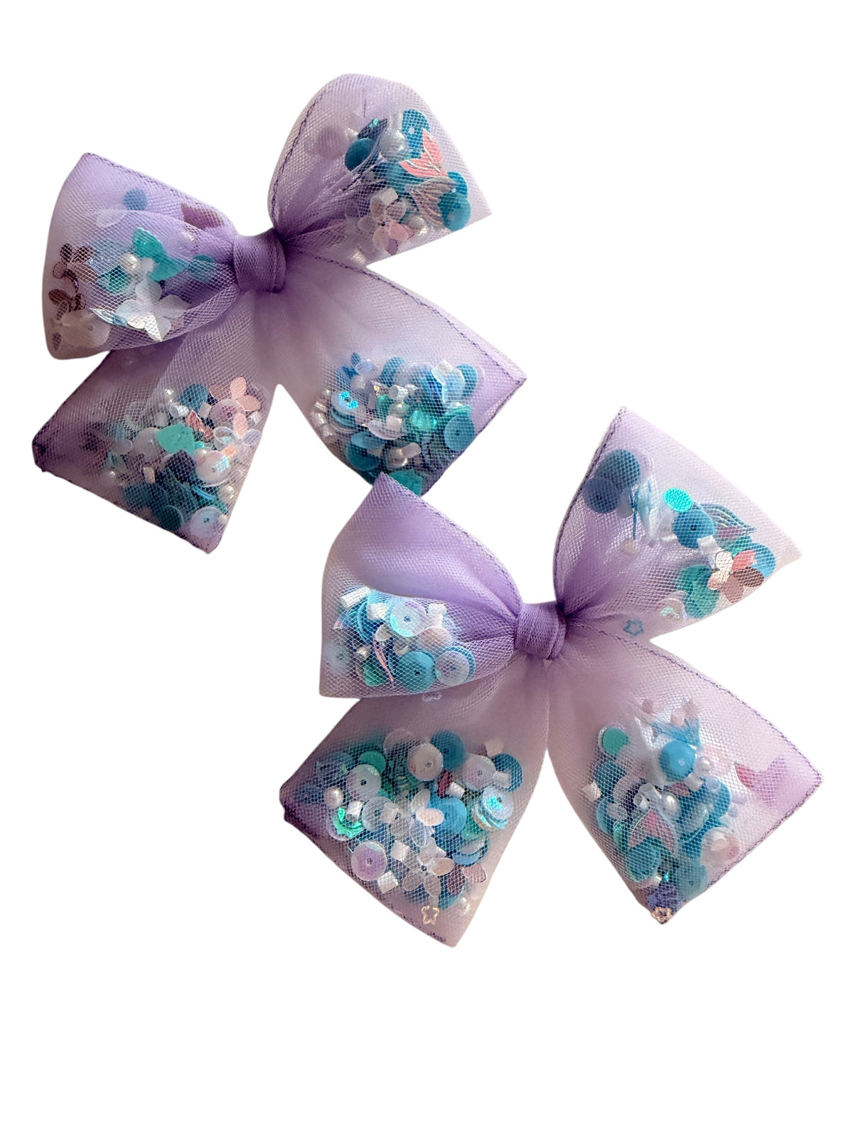 Two lavender purple tulle hair bows filled with blue, teal, and white sequins and glitter, shown on a plain white background.