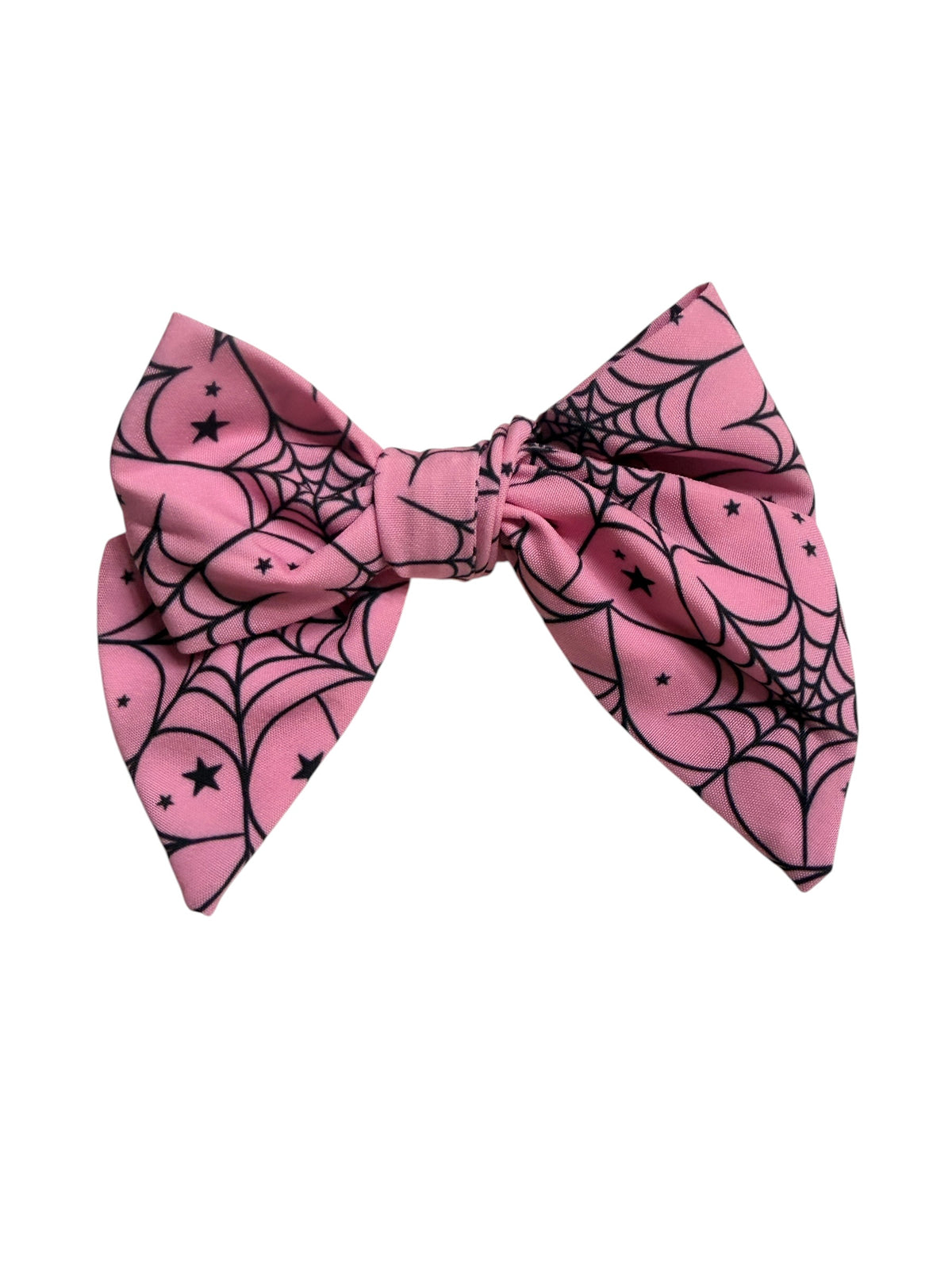 A pink hair bow featuring a black spiderweb and star pattern, presented on a solid white background.