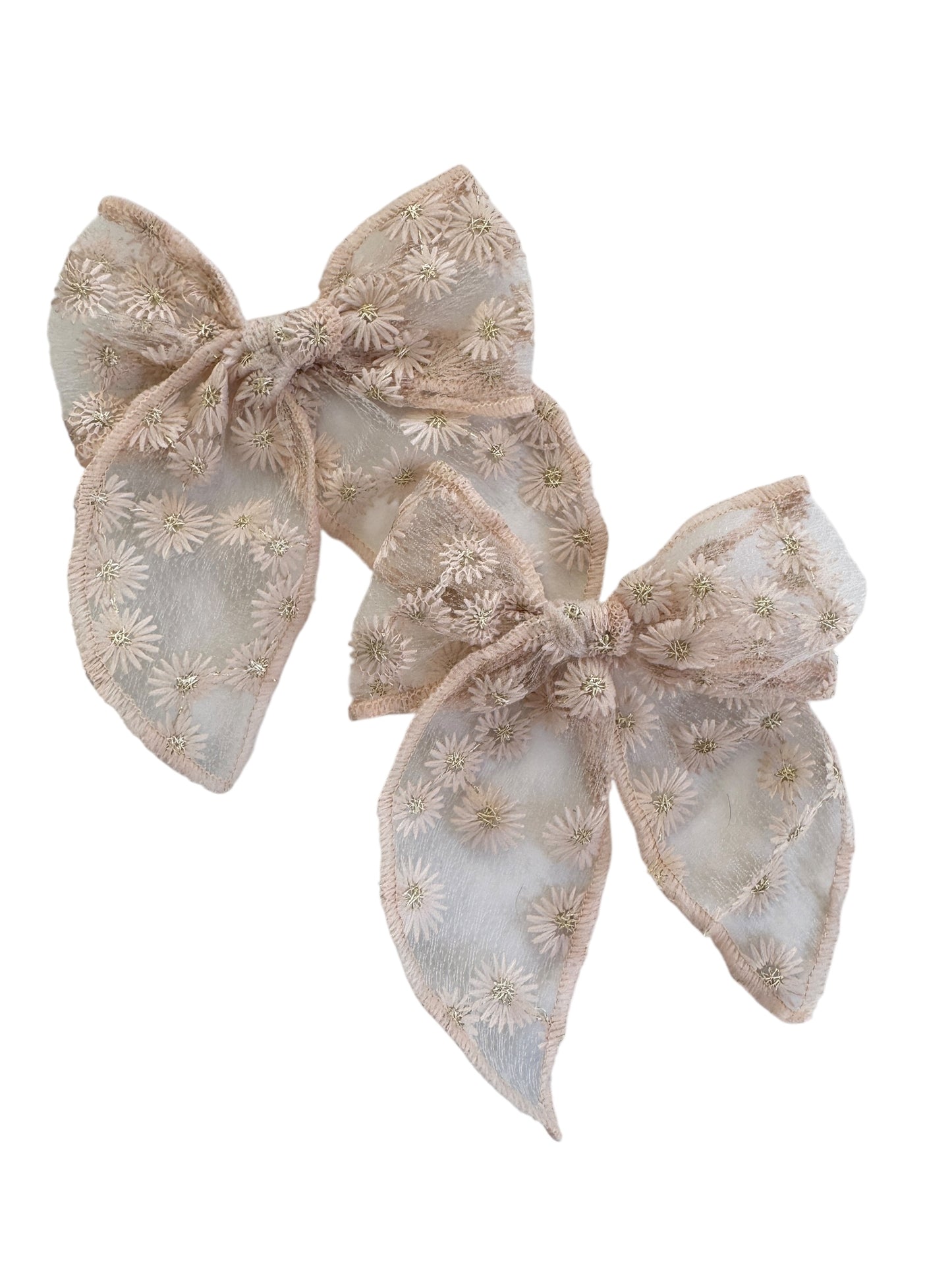 Two beige floral embroidered hair bows on a white background