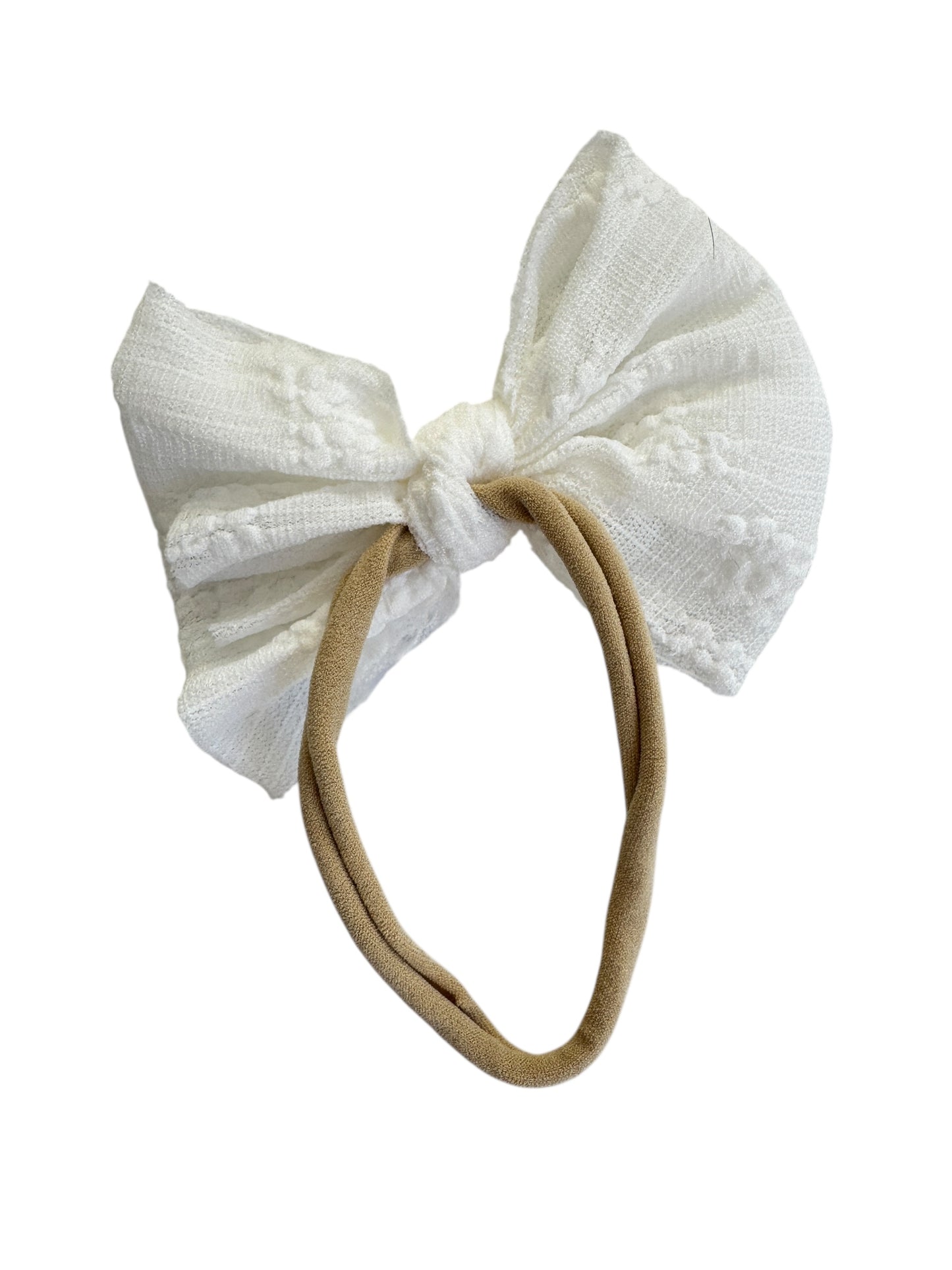 White textured bow headband on a beige band against a white background