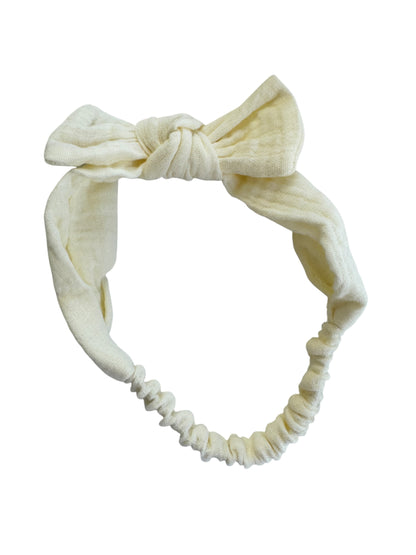 Cream-colored headband with a knotted design on a white background