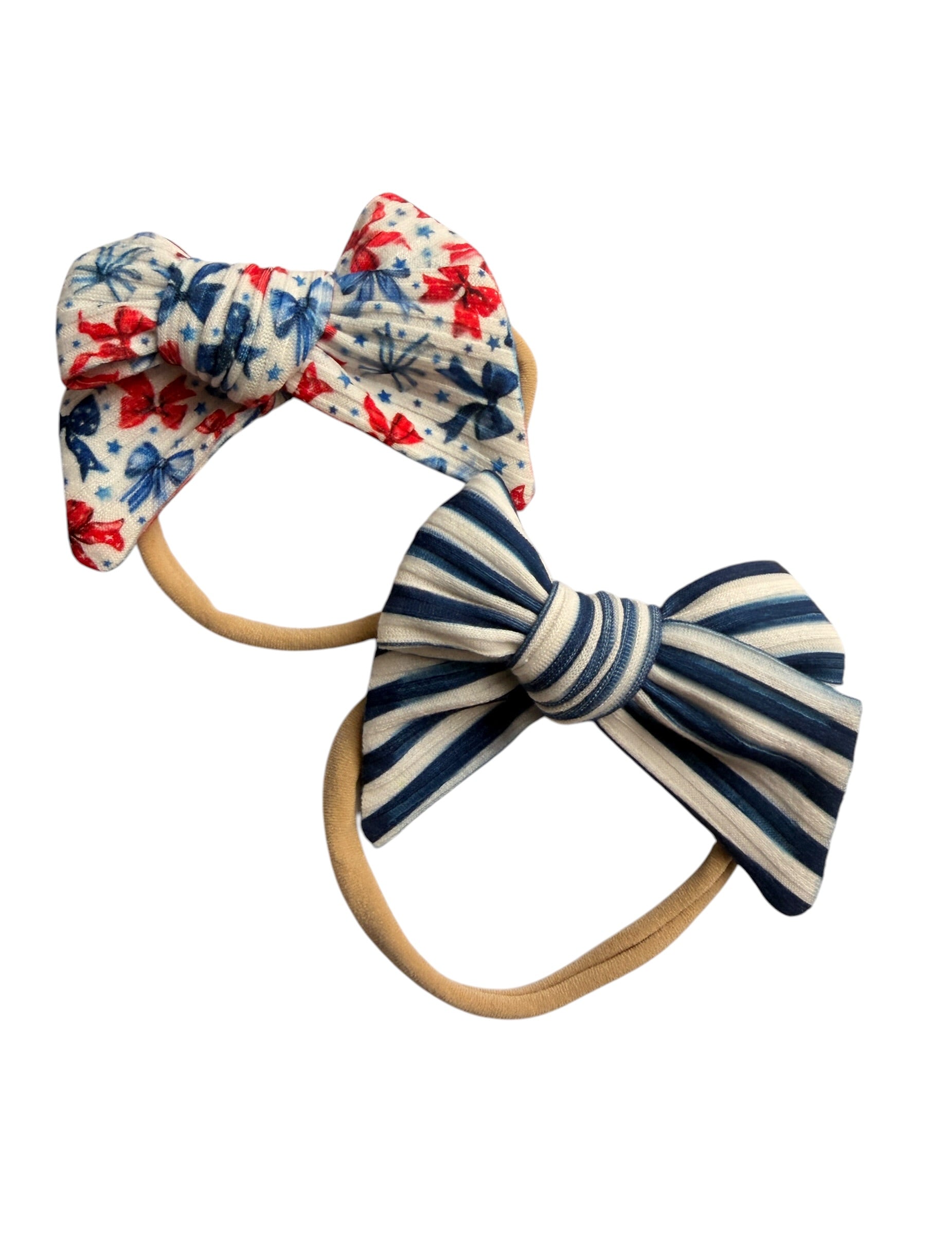 Two hair bows with floral and striped patterns on white background