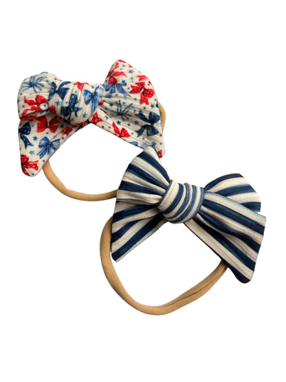 Two hair bows with floral and striped patterns on white background