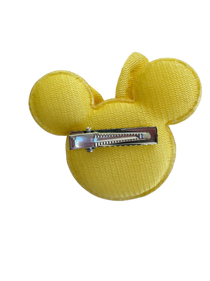 Yellow hair clip shaped like a mouse ear on a white background