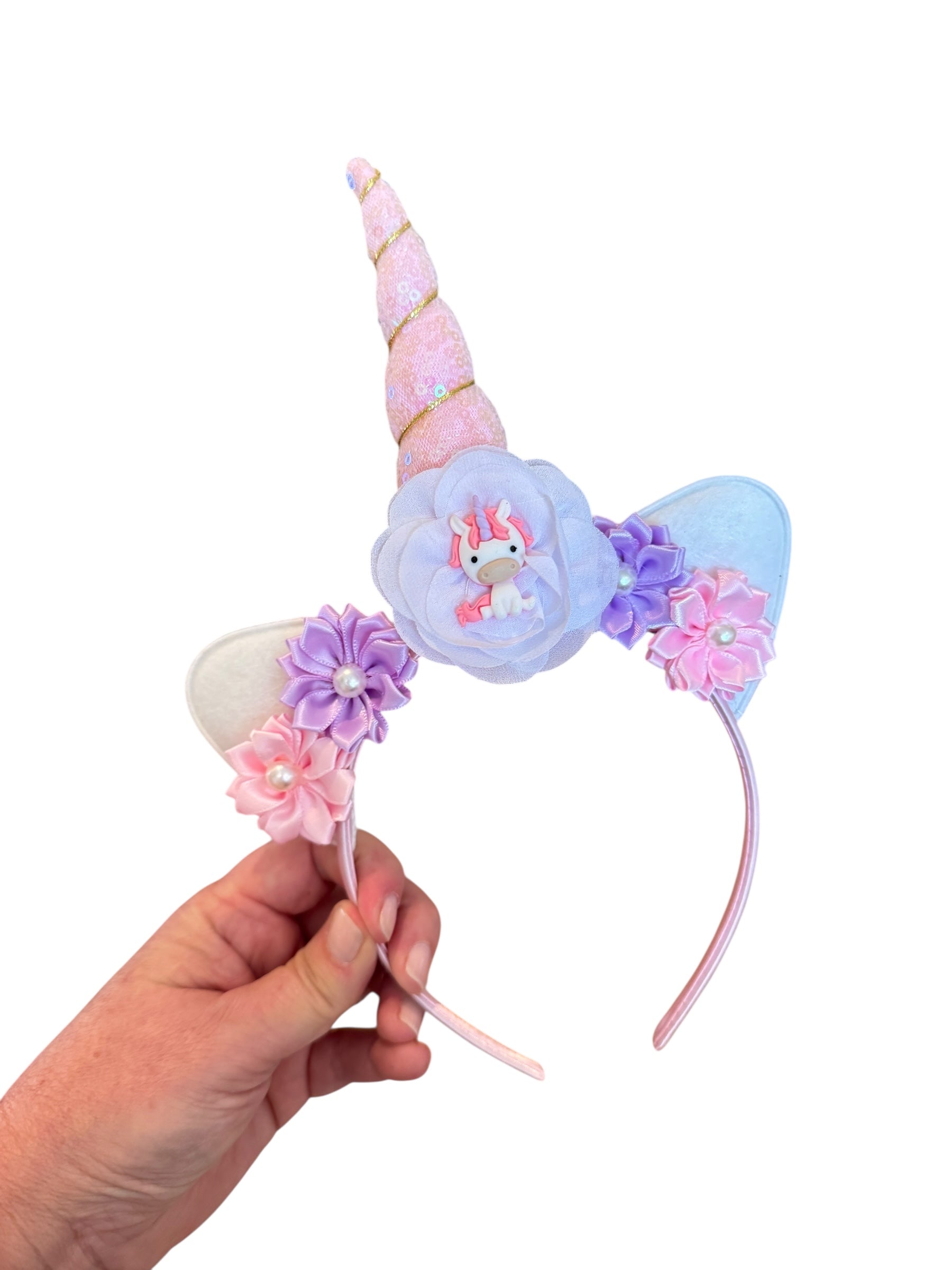 Unicorn-themed headband with floral decorations on a white background