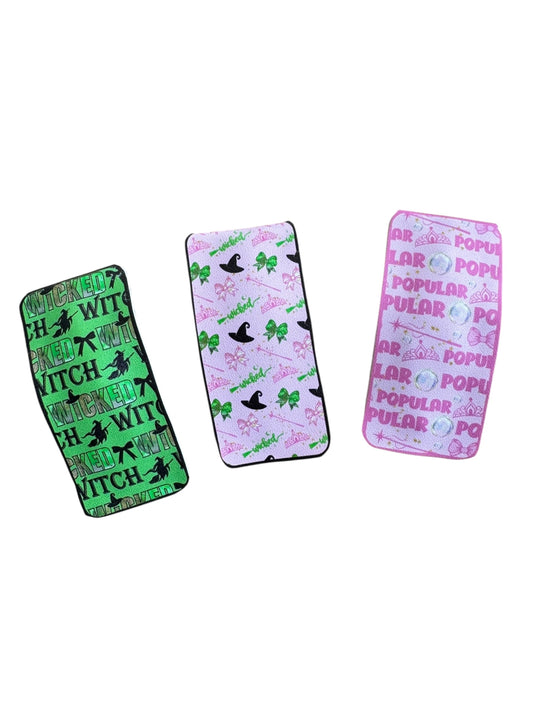 Three colorful snap clips with different designs on a white background