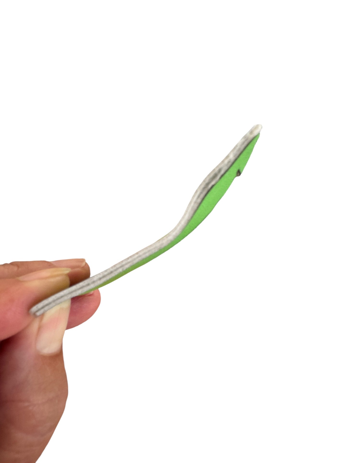 Hand holding a green and silver snap clip against a white background
