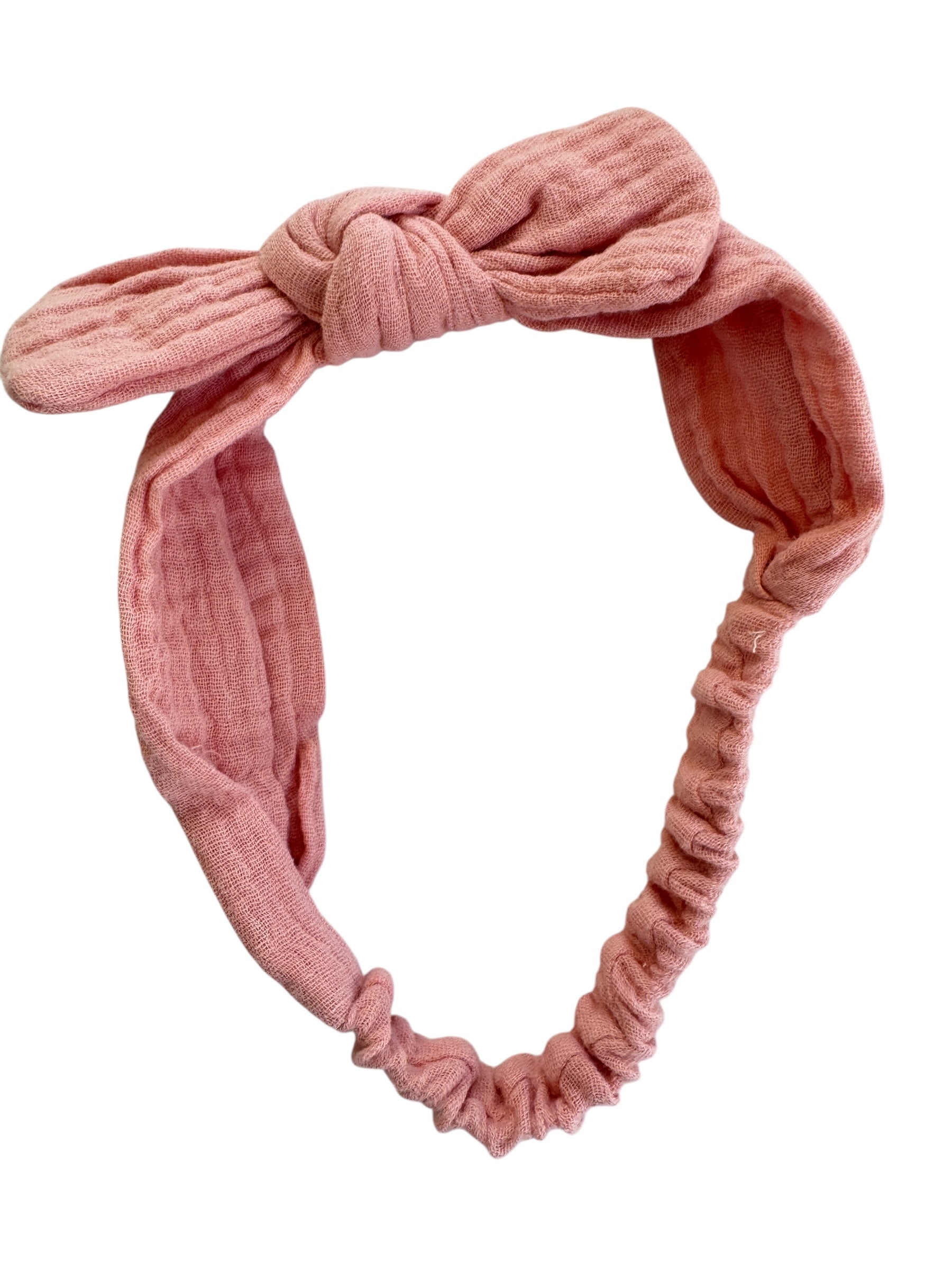 Pink knotted headband on a white background
