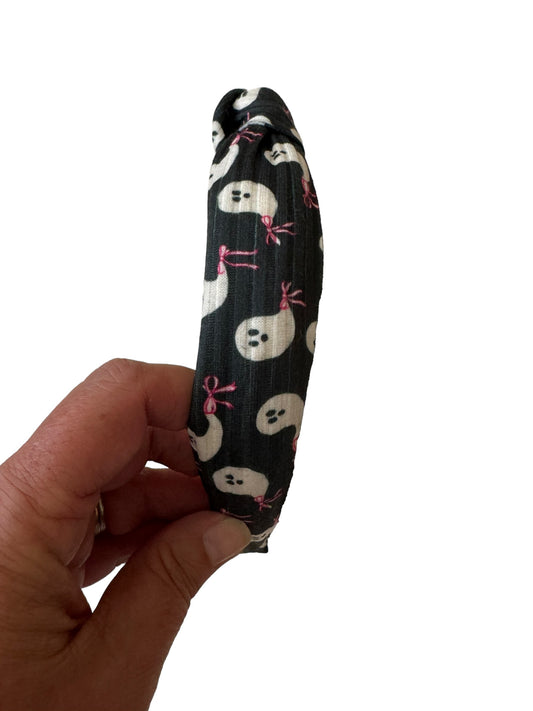 Packaged headband with black ghost patterns and pink bows, displayed on a white background.