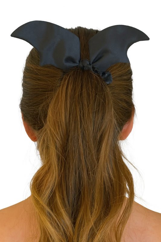 Black hair scrunchie on a ponytail against a white background