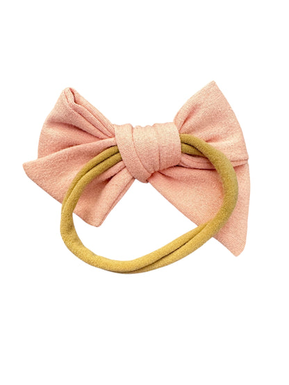 Pink bow hair accessory with a yellow band on a white background