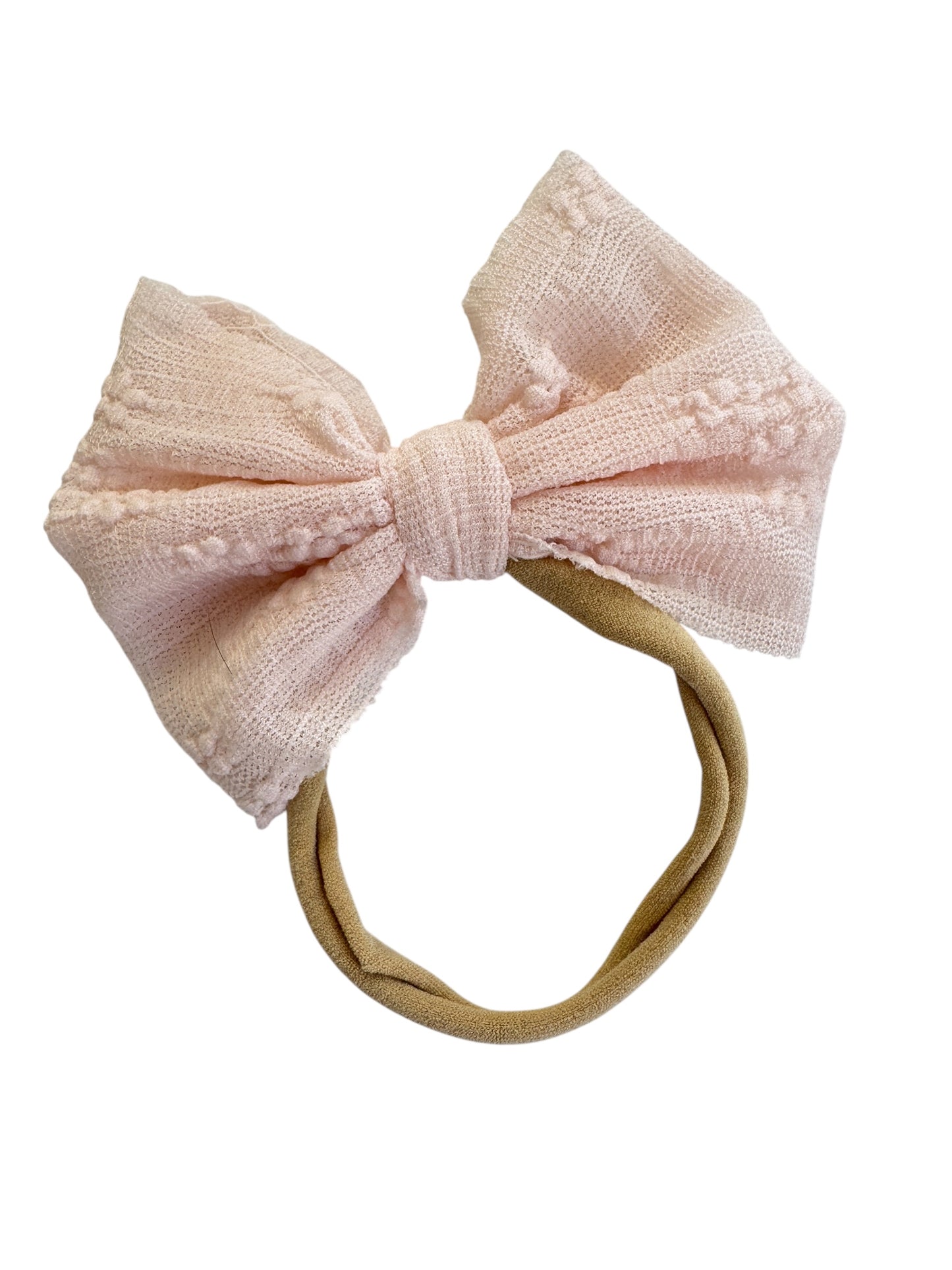 Pink textured bow headband on a white background
