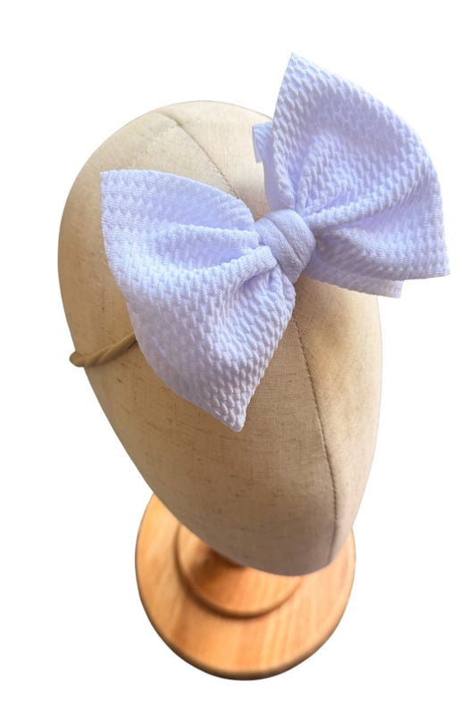 White textured bow on a mannequin head with a white background